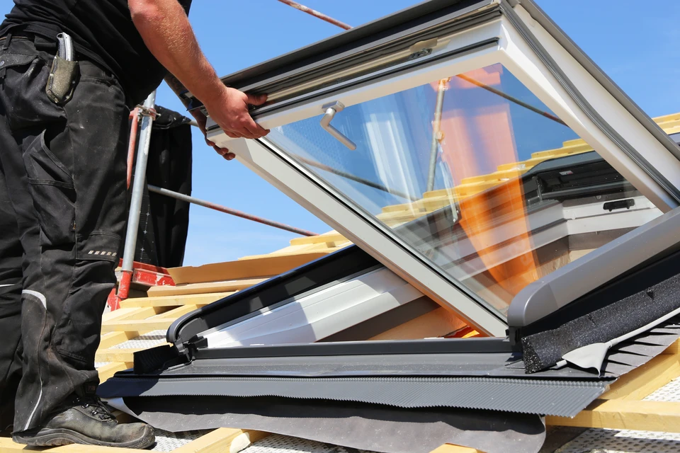 Artisan travaillant sur une toiture en rénovation, utilisant des outils de couverture