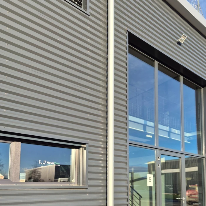 Façade et toiture d'une maison contemporaine, vue en contre-plongée, ciel bleu