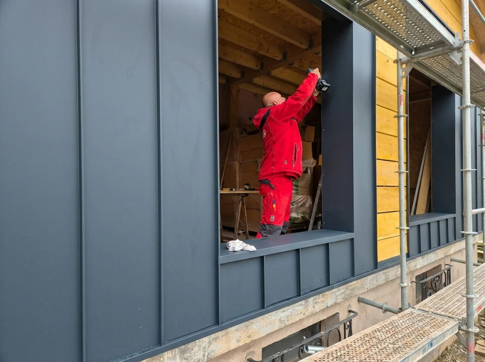 Façade de maison en rénovation avec échafaudage métallique tubulaire devant l'entrée