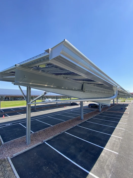Vue extérieure en contre-plongée d'un débord de toiture avec soffit en lambris PVC blanc, pose horizontale rainurée